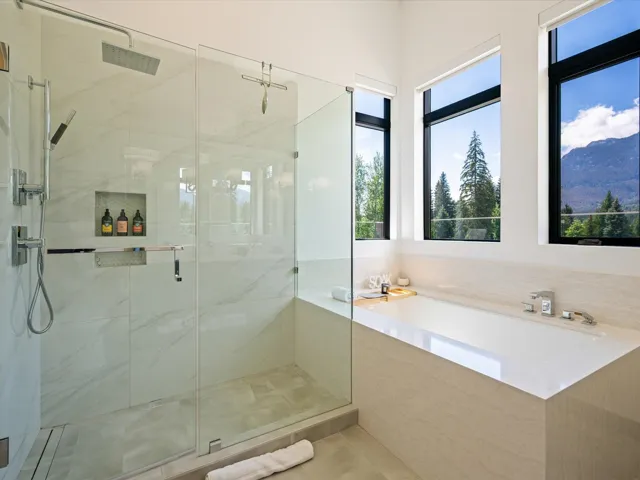 Full bath featuring a bath, a marble finish shower, a mountain view, and tile patterned flooring