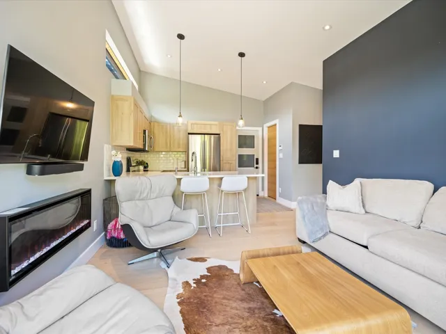 Living room featuring light wood-style floors, high vaulted ceiling, and recessed lighting