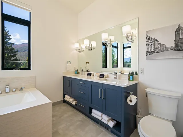 Full bath featuring a bath, double vanity, and light tile patterned flooring