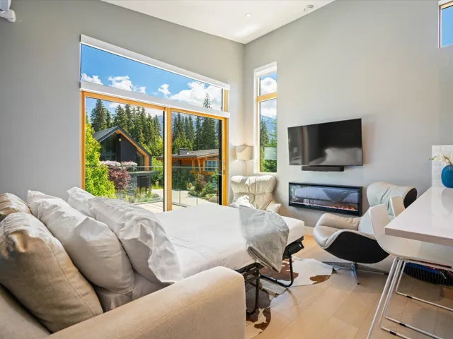 Living room with wood finished floors and a glass covered fireplace