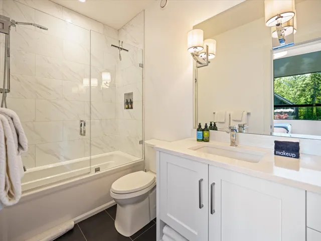 Full bathroom featuring combined bath / shower with glass door, vanity, and dark tile patterned floors