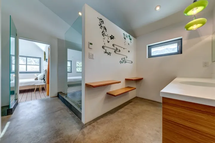 Full bathroom with ensuite bath, finished concrete flooring, vanity, and vaulted ceiling