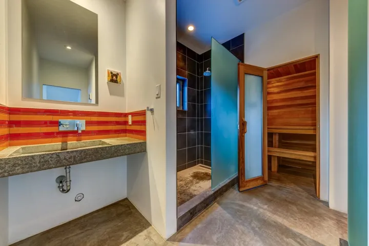 Bathroom with a stall shower, a sauna / steam room, recessed lighting, and concrete flooring