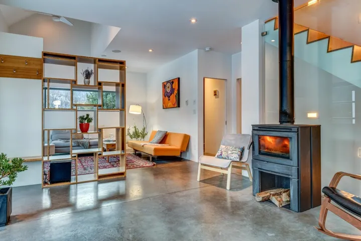 Living area with finished concrete floors, a wood stove, and recessed lighting