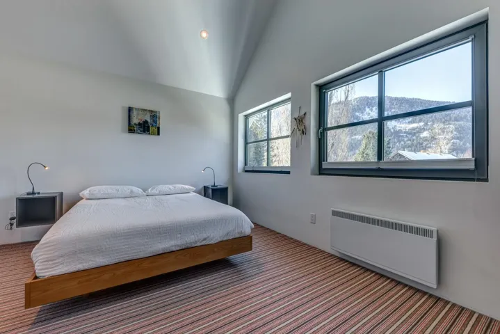 Carpeted bedroom featuring radiator heating unit, recessed lighting, and high vaulted ceiling