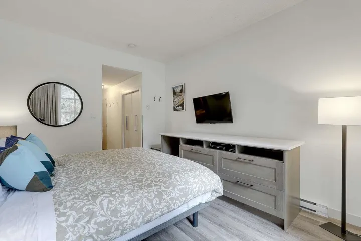 Bedroom with a baseboard heating unit and light wood-style floors