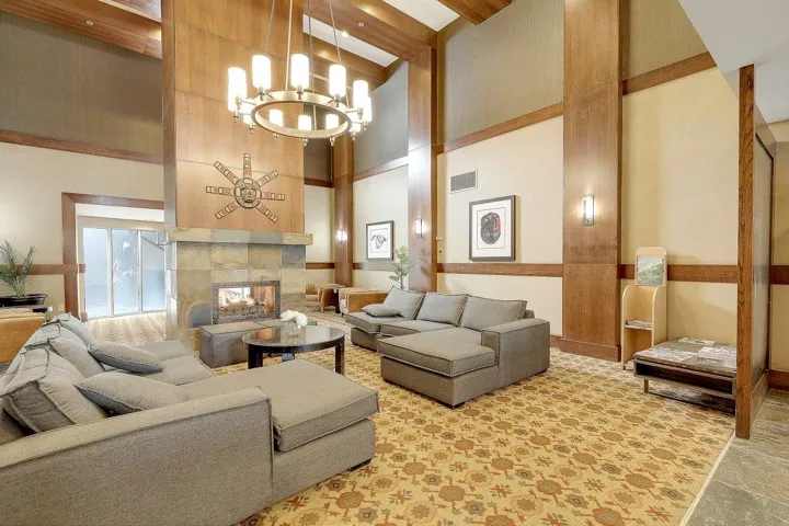 Living area with a tile fireplace, a high ceiling, and suspended lighting