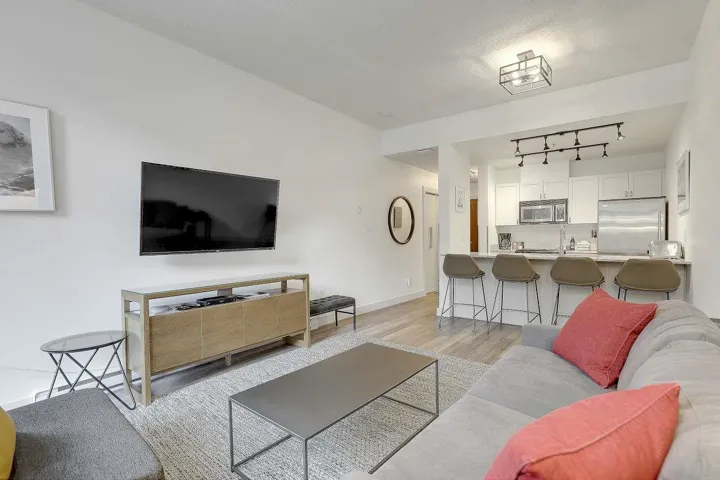 Living room featuring light wood-style flooring and rail lighting