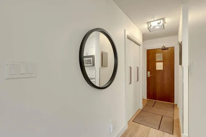Corridor featuring light wood-type flooring and a textured ceiling