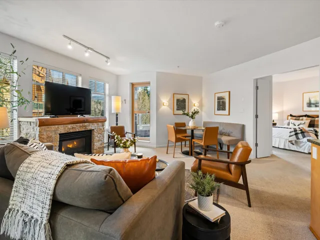 Living room with carpet floors and a stone fireplace