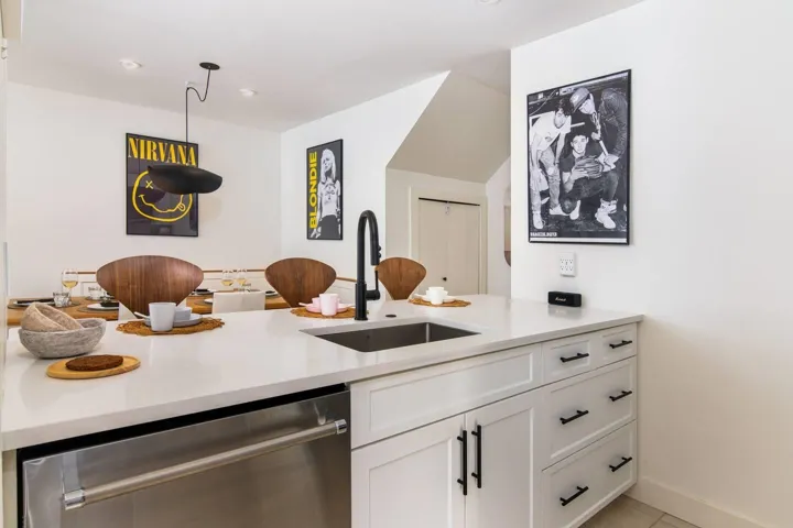Kitchen featuring stainless steel dishwasher, white cabinets, light stone counters, a peninsula, and recessed lighting
