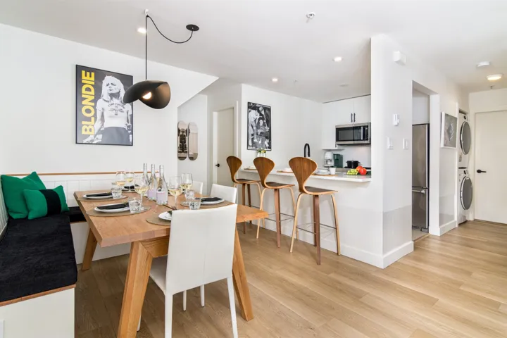 Dining space featuring light wood-type flooring, stacked washer / drying machine, and recessed lighting