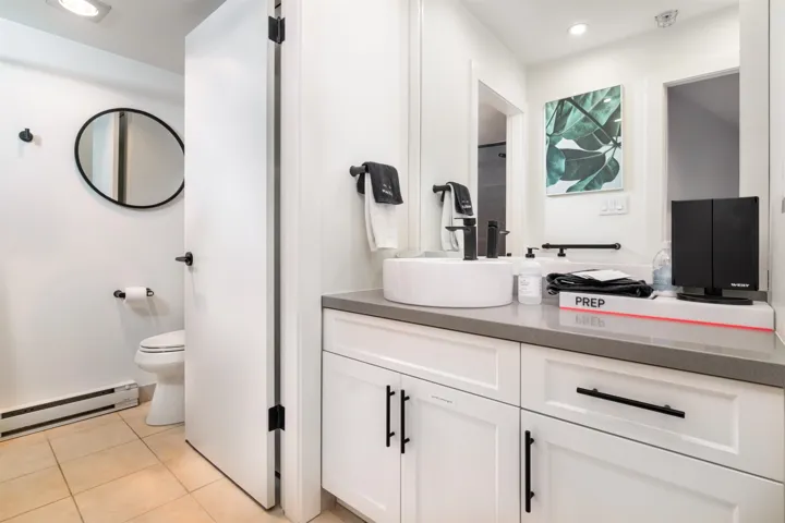 Full bath with a baseboard heating unit, recessed lighting, light tile patterned floors, and vanity