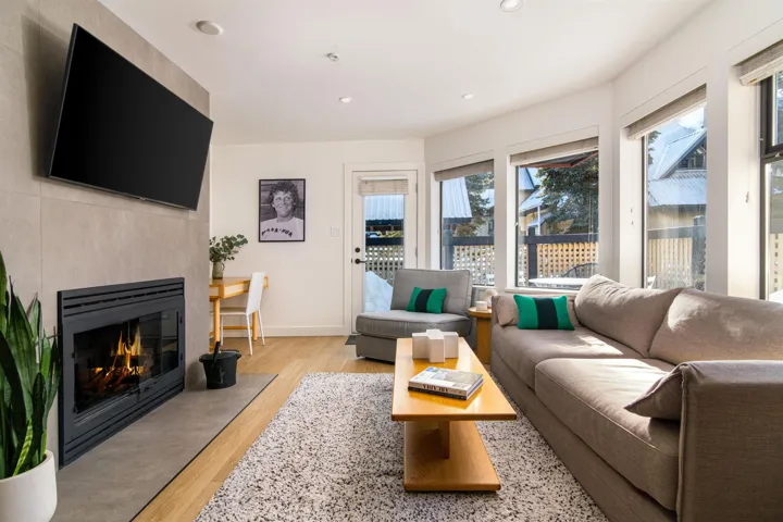 Living area featuring light wood finished floors, recessed lighting, and a fireplace with flush hearth