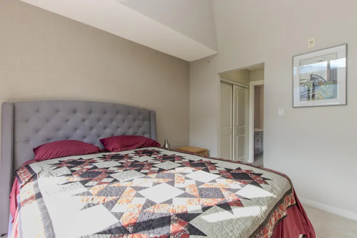 Bedroom featuring light carpet, a closet, and a towering ceiling
