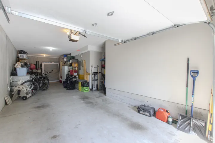 Garage with a garage door opener and freestanding refrigerator
