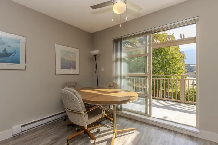 Dining area with a baseboard heating unit, wood finished floors, and ceiling fan