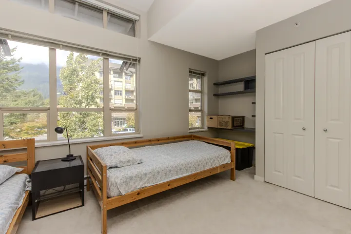 Bedroom with light colored carpet and a closet