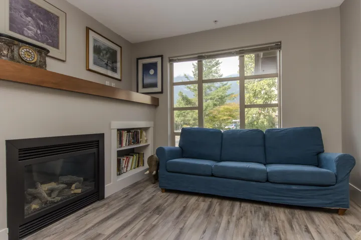 Sitting room featuring a glass covered fireplace and light wood finished floors