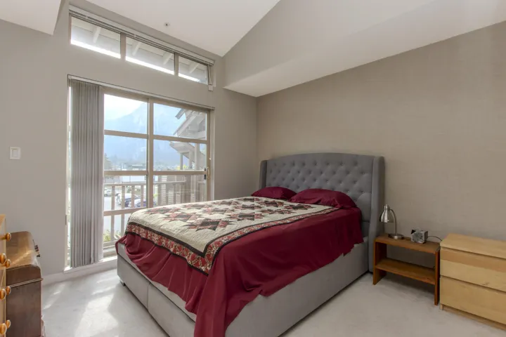 Bedroom featuring light carpet and vaulted ceiling