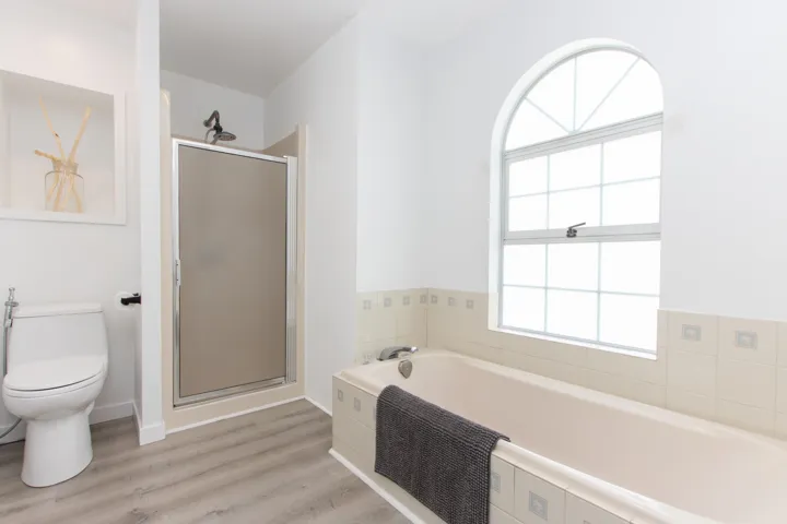 Bathroom featuring a garden tub, a shower stall, and wood finished floors