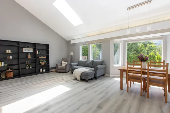 Living area with wood finished floors and high vaulted ceiling