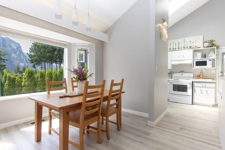 Dining area with vaulted ceiling, light wood-style flooring, and a mountain view