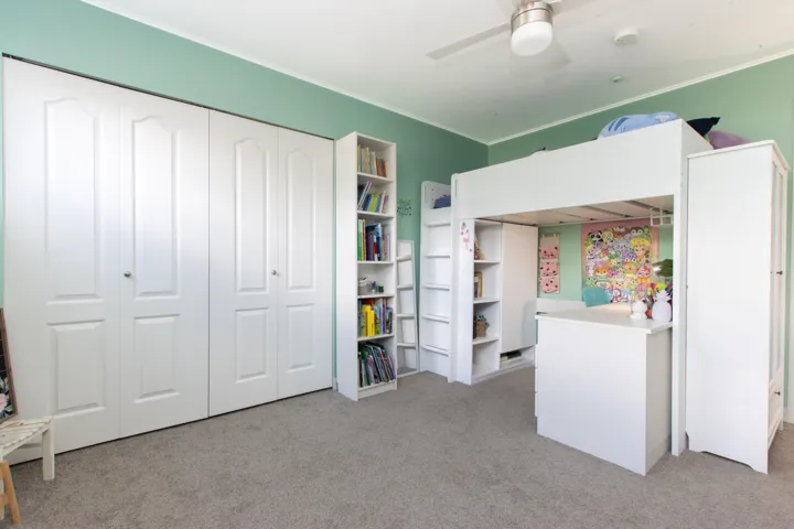 Bedroom with light colored carpet, crown molding, a closet, and a ceiling fan