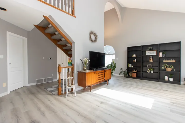 Living area featuring light wood-style flooring and high vaulted ceiling