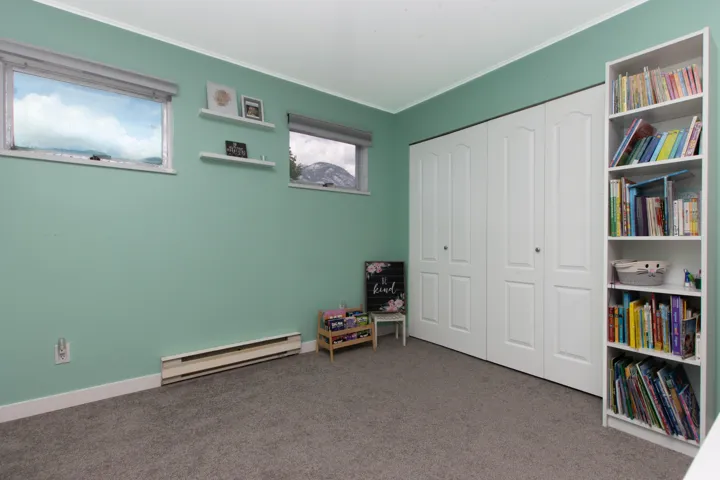 Game room with a baseboard heating unit, carpet, and ornamental molding