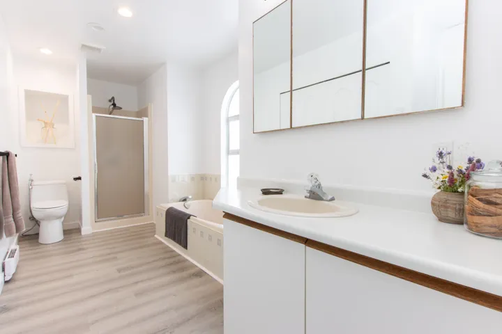 Bathroom with vanity, a stall shower, a bath, wood finished floors, and recessed lighting