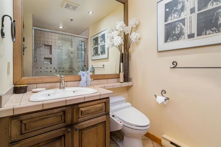 Full bath featuring vanity, recessed lighting, toilet, a shower stall, and a baseboard radiator