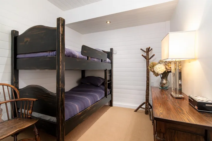Carpeted bedroom with baseboards and wood walls