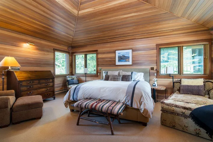 Bedroom featuring carpet flooring, wooden walls, a baseboard radiator, vaulted ceiling, and wooden ceiling