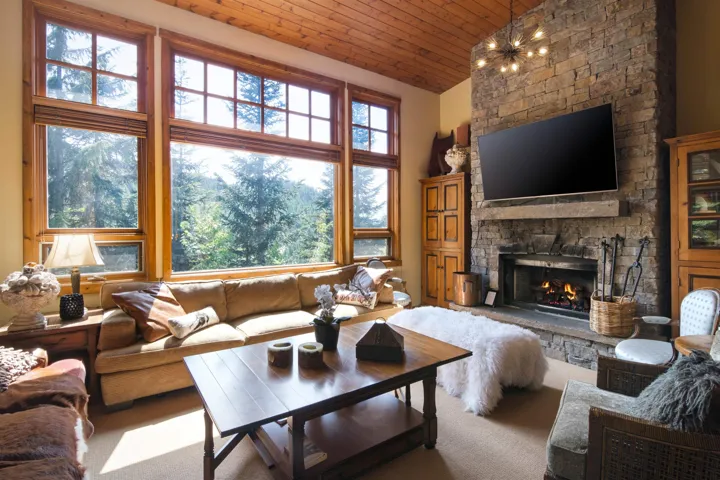 Carpeted living room with a fireplace, wood ceiling, and vaulted ceiling