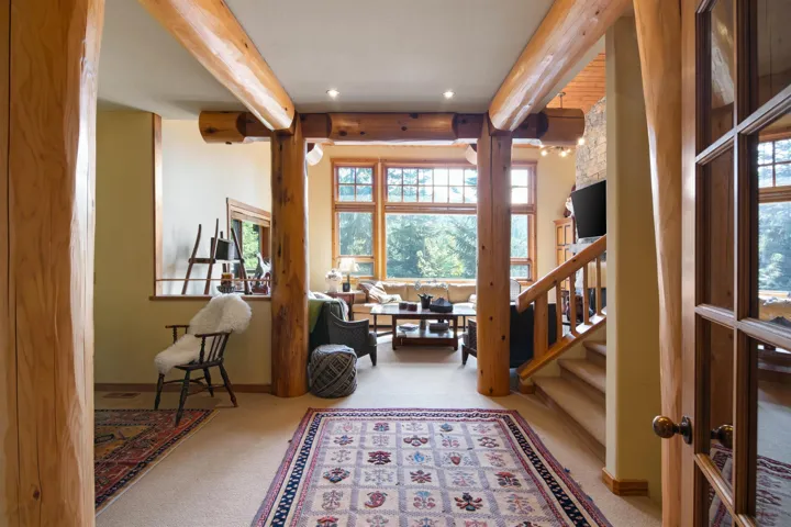 Living area featuring plenty of natural light, beamed ceiling, and carpet floors