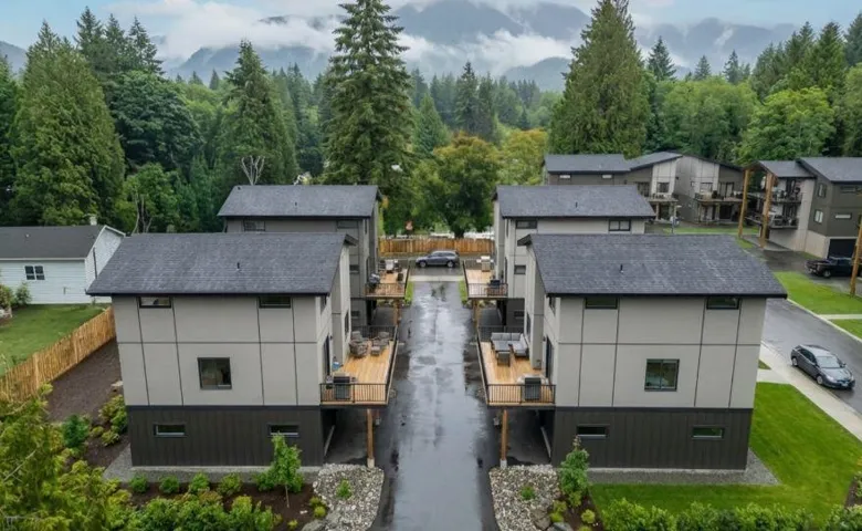 Modern-style exterior with light gray and dark gray siding, featuring private wood decks