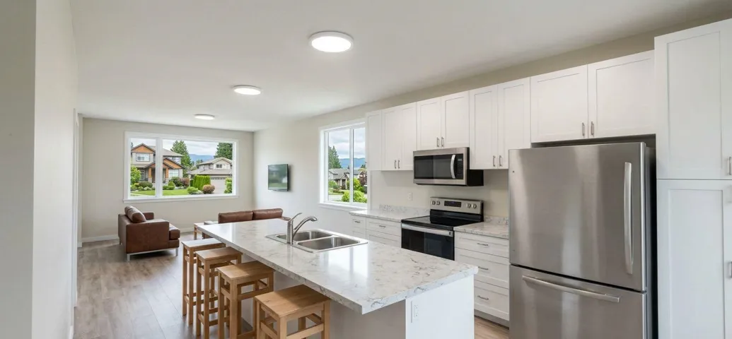 White cabinetry, stainless steel appliances, dual basin sink, wood-finish flooring, and recessed lighting