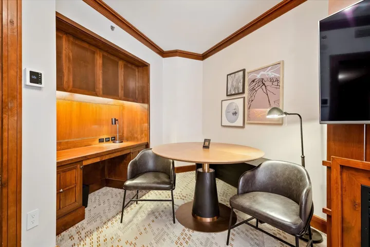 Office area with crown molding and built in study area