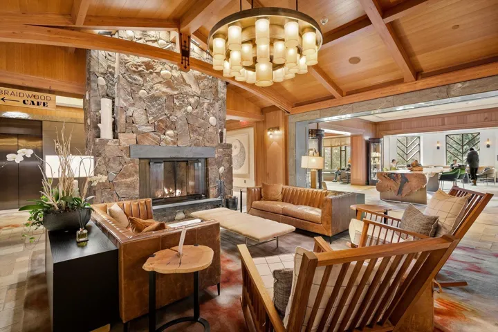 Common area with vaulted ceiling with beams, wood walls, and wooden ceiling