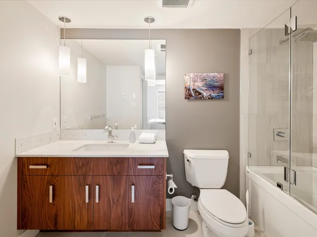 Full bath with toilet, shower / bath combination with glass door, and vanity