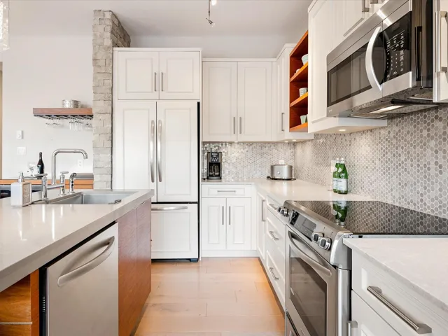 Kitchen featuring open shelves, decorative backsplash, a sink, light wood finished floors, and appliances with stainless steel finishes
