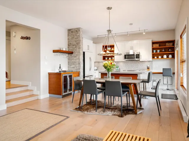 Dining space featuring plenty of natural light, baseboards, stairway, light wood-type flooring, and beverage cooler
