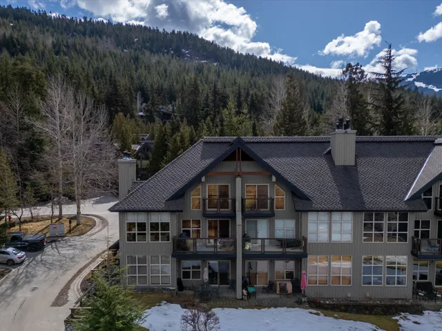 Rear view of house with a chimney, a wooded view, and a mountain view