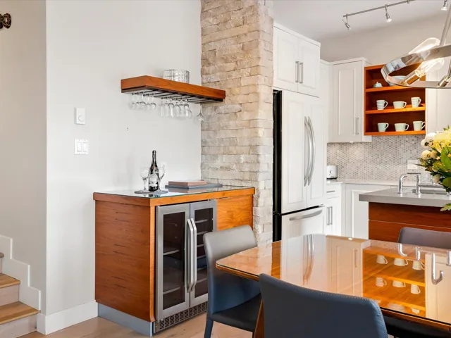 Kitchen with open shelves, wine cooler, backsplash, freestanding refrigerator, and white cabinets