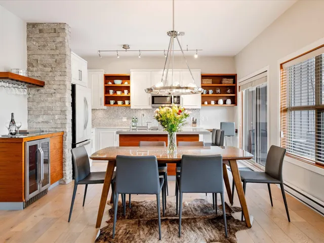 Dining area with baseboard heating, wine cooler, and light wood-style floors