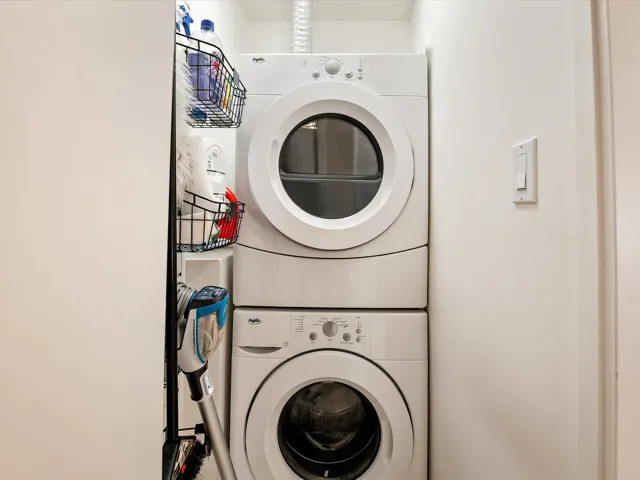 Washroom featuring stacked washer / dryer and laundry area