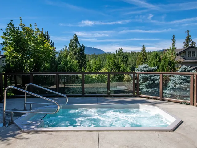 View of pool with an in ground hot tub and a mountain view