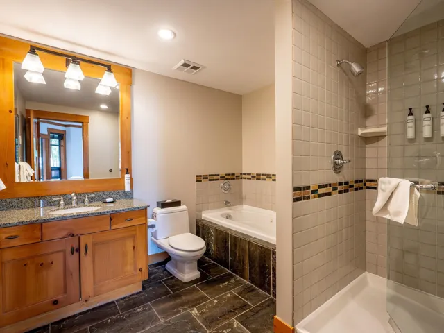 Full bathroom with vanity, a garden tub, tiled shower, and recessed lighting