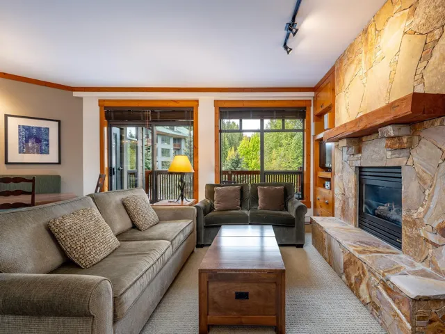 Living room featuring track lighting, a fireplace, carpet flooring, and crown molding
